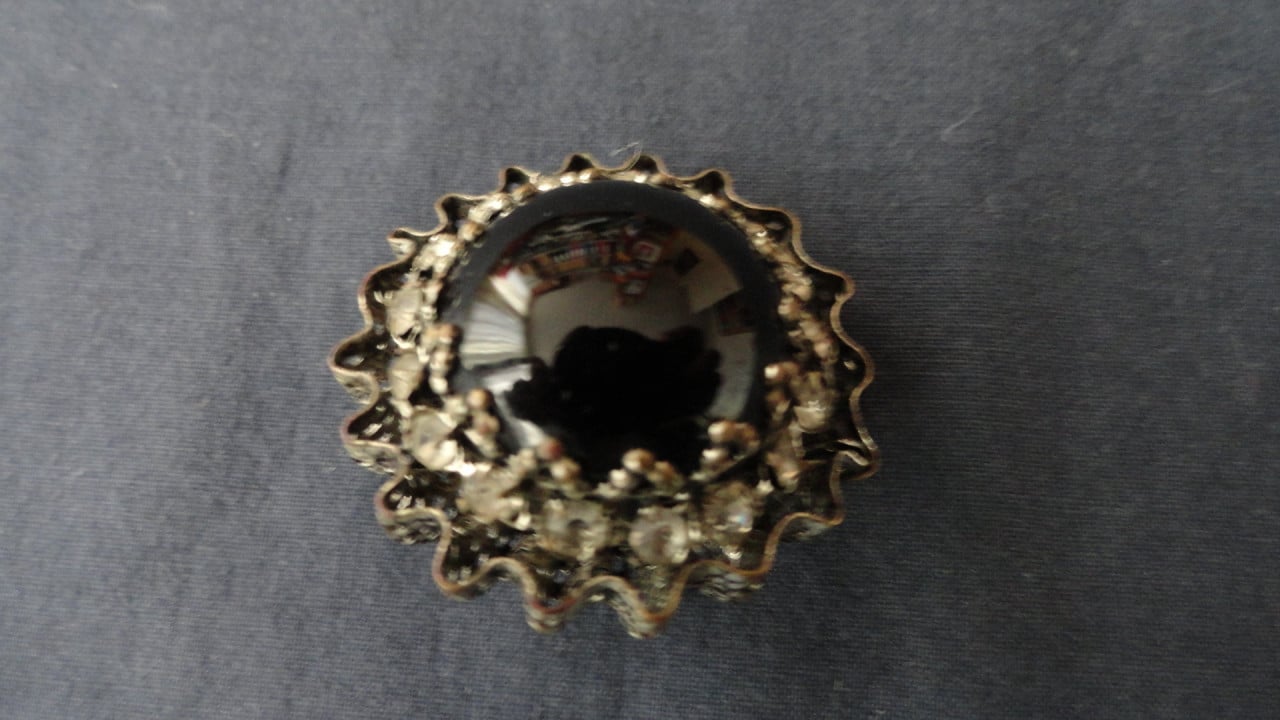 Speld met zwarte steen met strass steentjes eromheen. Leuk ding. (zie foto’