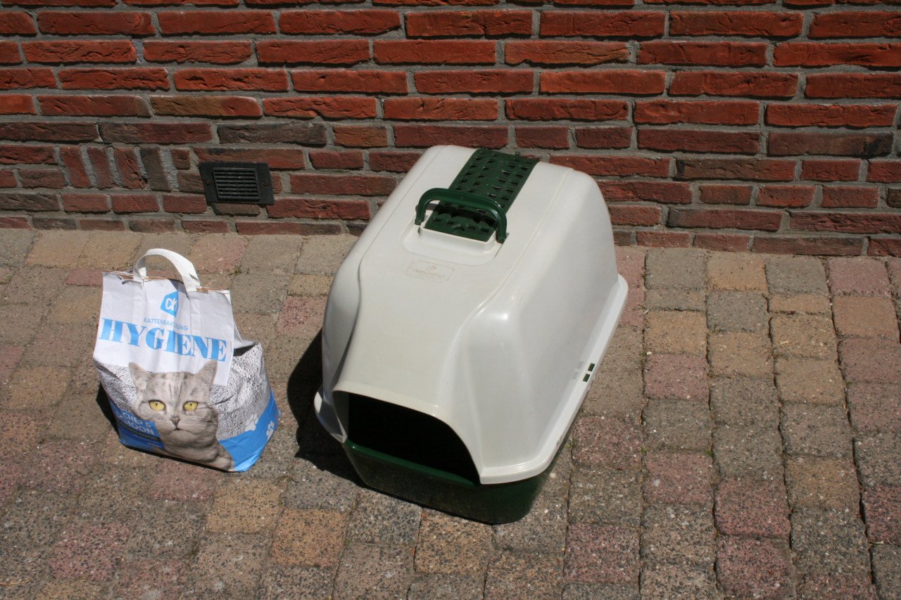 Transportbox en een kattenbak met een zak kattenbakvulling