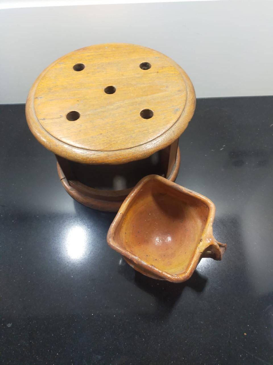 Antieke ronde voetenstoof met aardewerk schaaltje