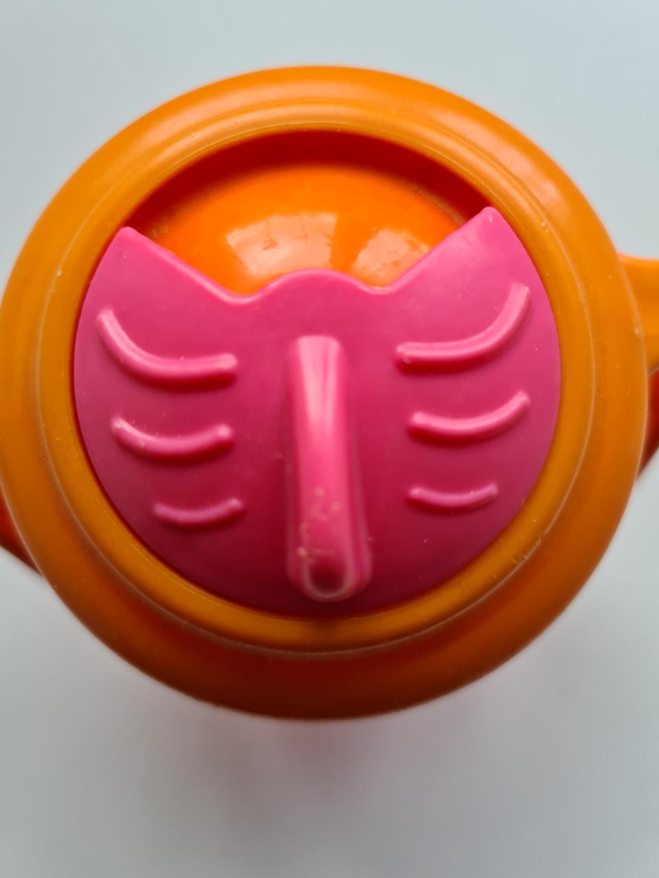 Munchkin Tip & Sip rietjesbeker met oranje deksel en roze beker.