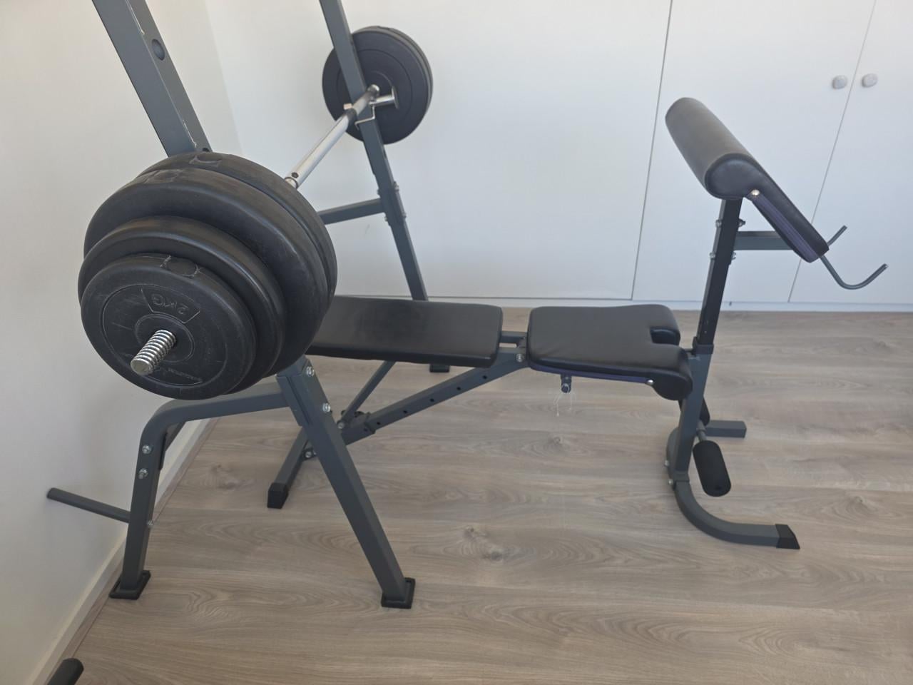 Fitnessbank met halterstang en gewichten