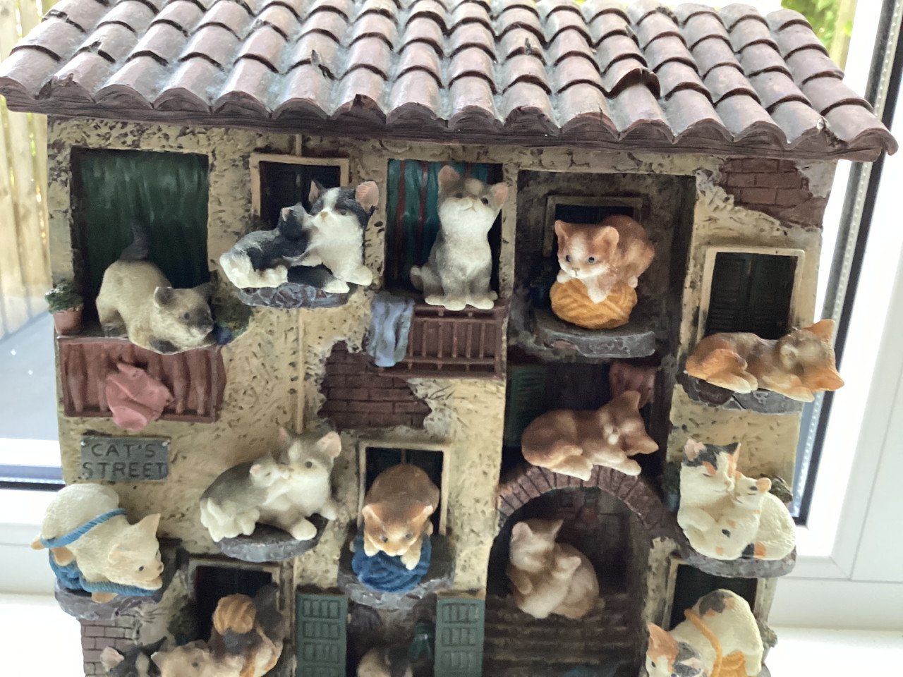 Stenen kattenluik met katten beeldjes