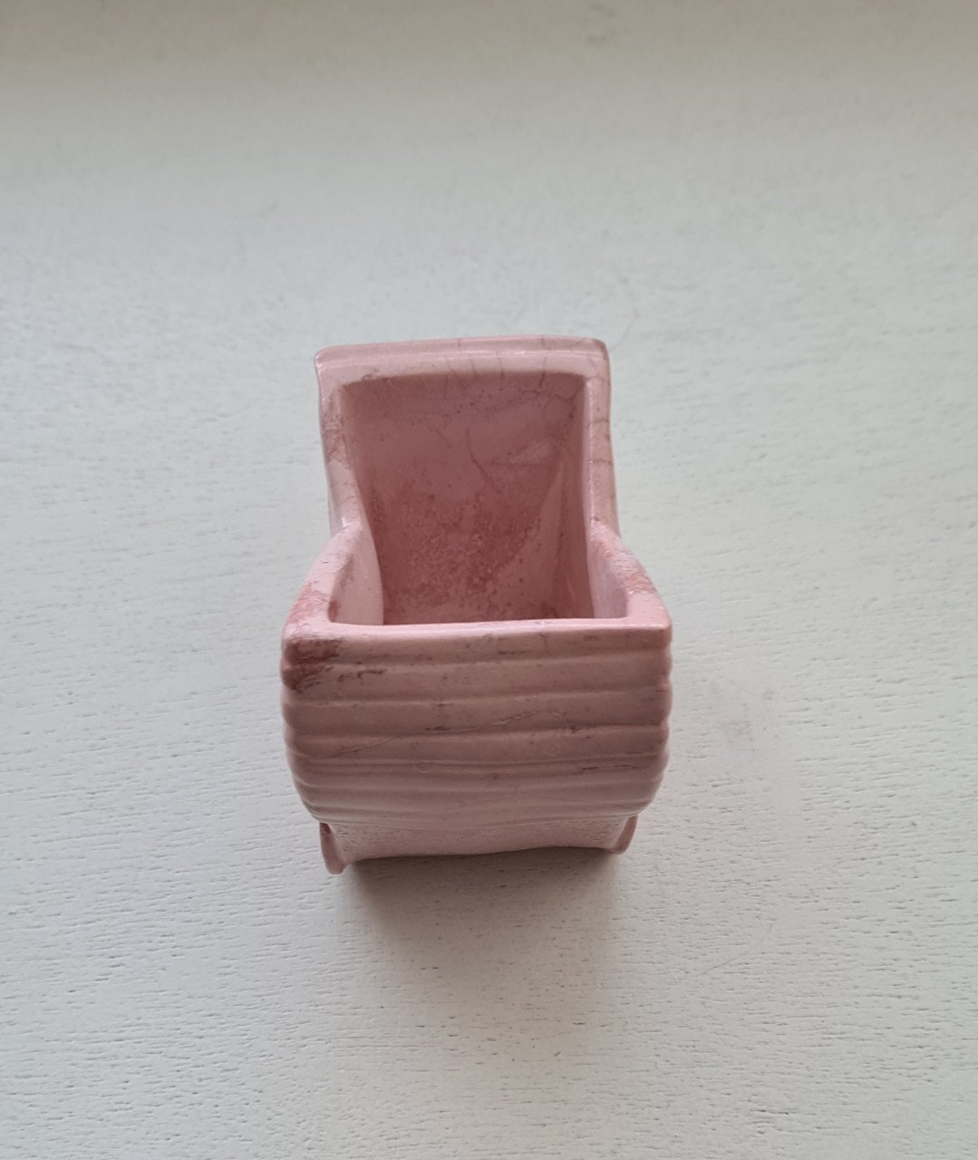 Schattig klein roze bloempotje in de vorm van een kinderwagen