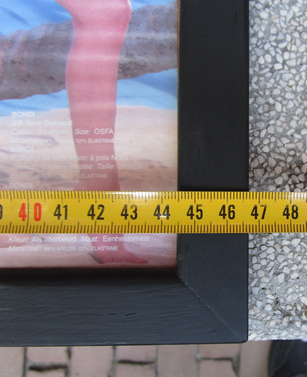 Ingelijste folder van dames badkleding achterontspiegelt glas.