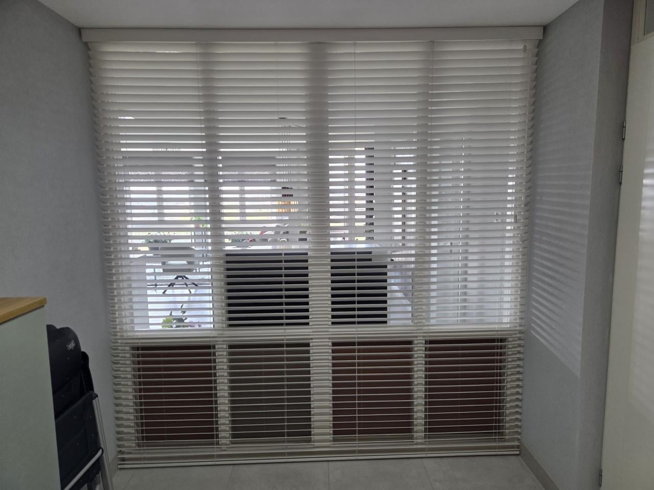 Witte houten jaloezie in nette staat.