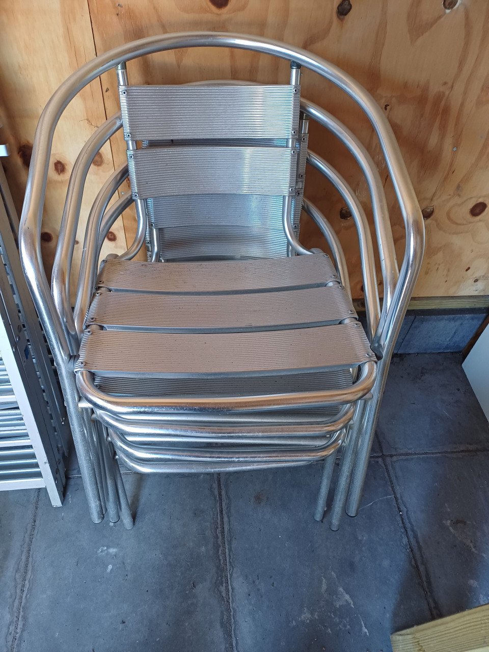 4 metalen buitenstoelen met grijze zitkussens. Afhalen in Goes