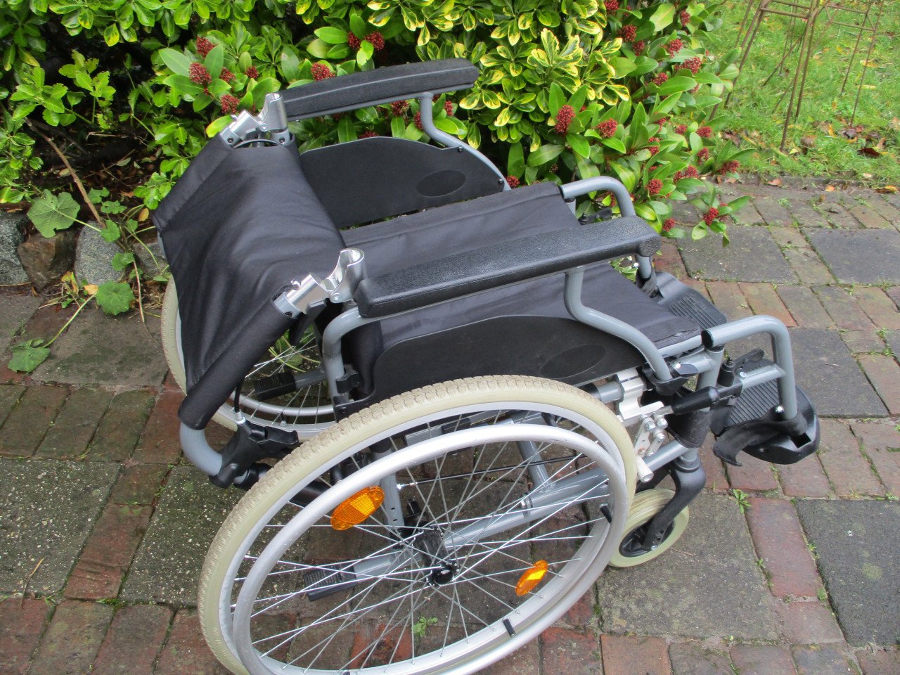 Zeer handige rolstoel met handremmen en neerklapbare duwhandgrepen