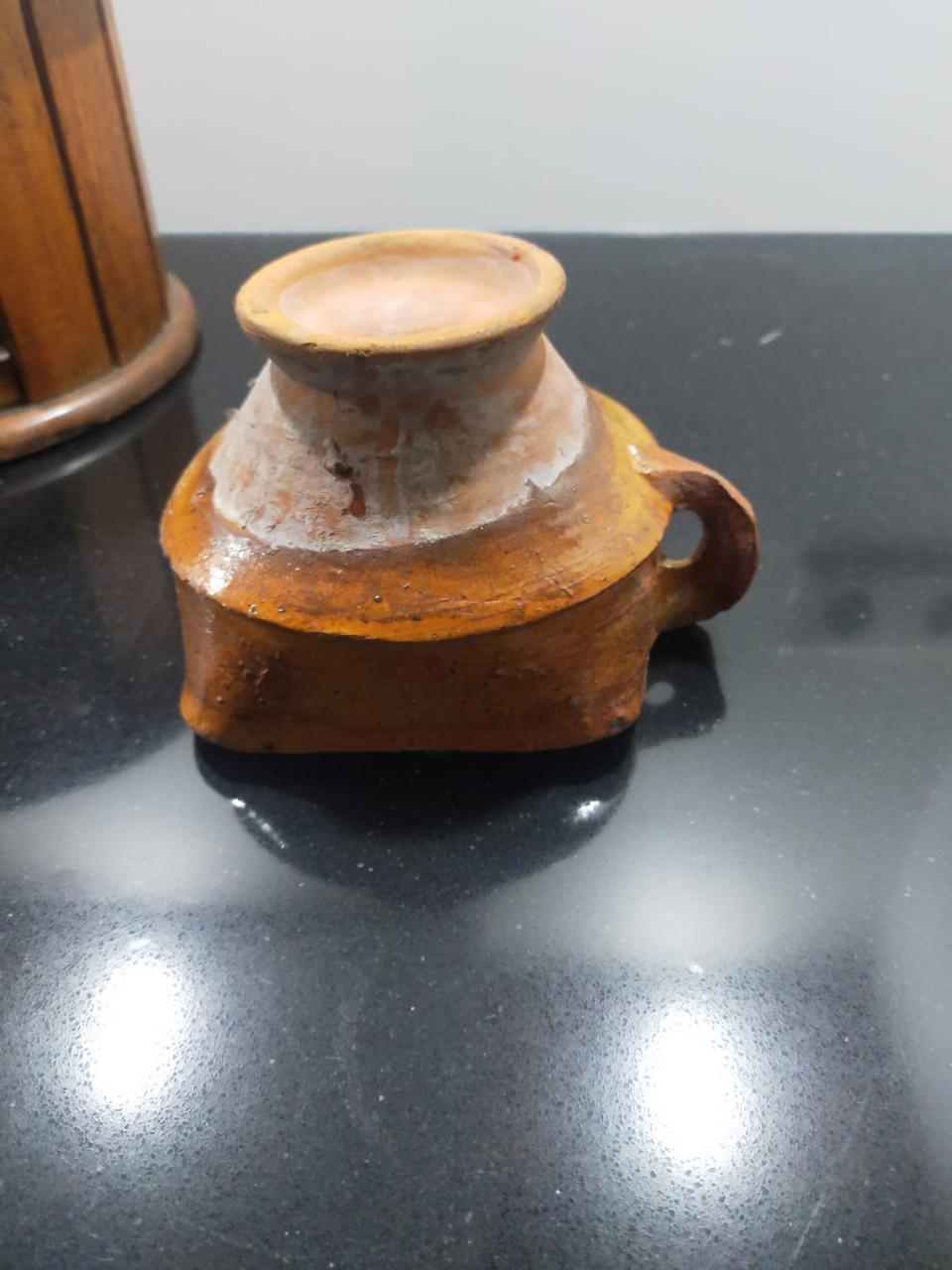 Antieke ronde voetenstoof met aardewerk schaaltje