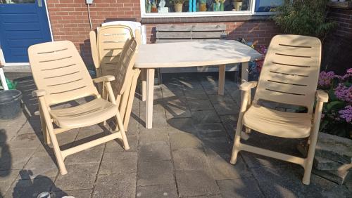 4 Tuinstoelen, lichtgeel of crèmekleurig met verstelbare rugleuning.