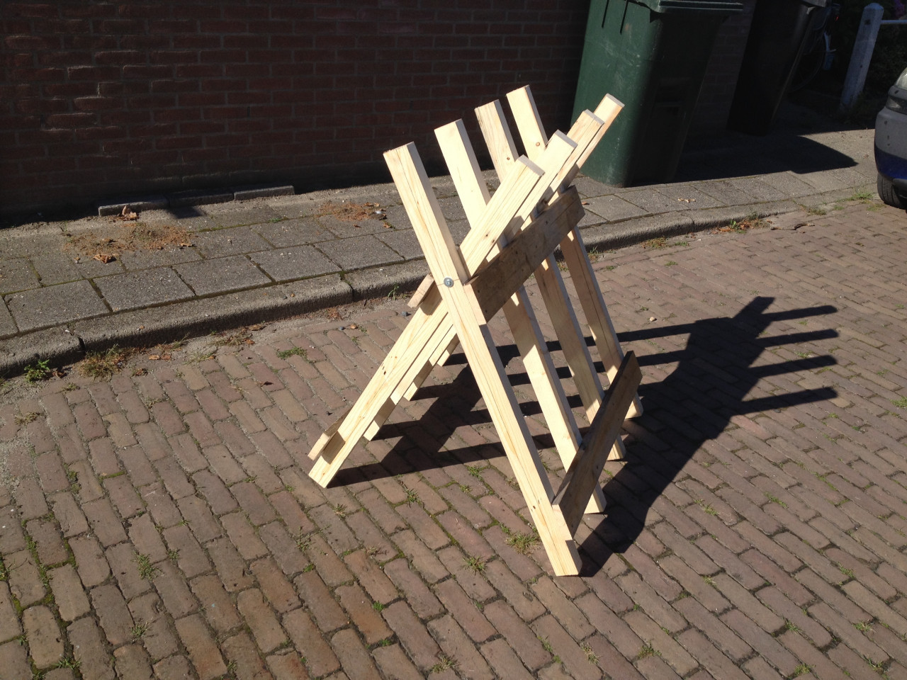 Rechtop hout doorzagen met kettingzaag en robuste zaagbok als werkbank