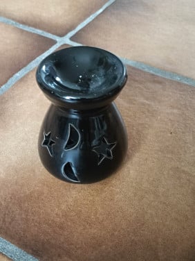 Geurbrander. Zwart met 4 uitsnijdingen, 2 keer een ster en 2 keer de maan.