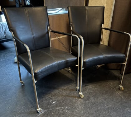 Twee eetkamerstoelen op wieltjes.