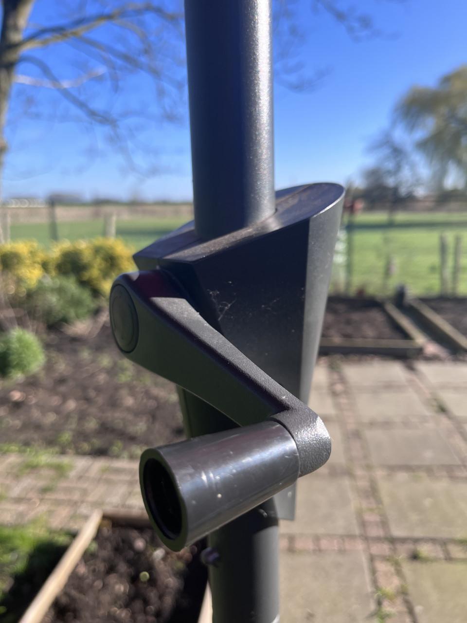 Oranje parasol met voet van steen