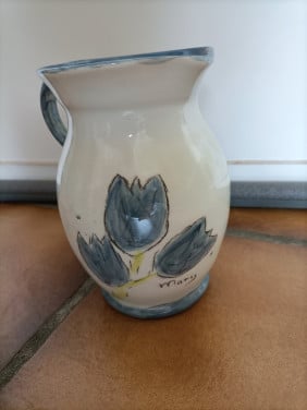 Kannetje met oor. Crème kleurig met blauwe bloemen/ tulpen.