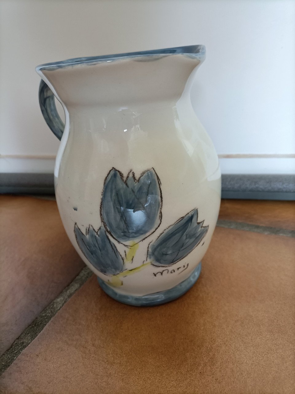 Kannetje met oor. Crème kleurig met blauwe bloemen/ tulpen.