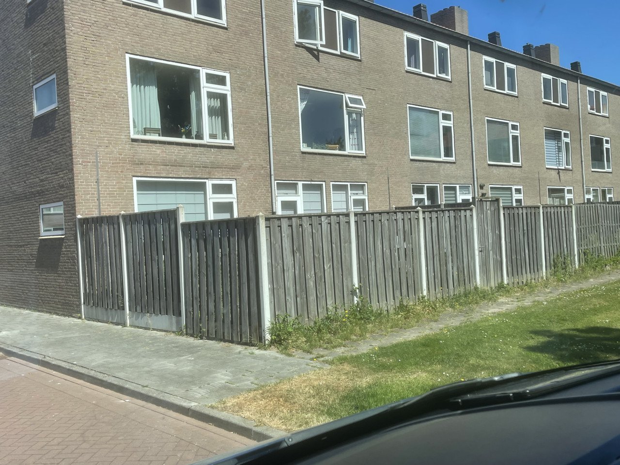 Schutting met betonnenpalen en poort