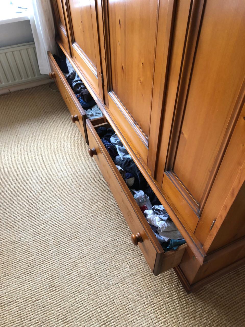 Grote houten kledingkast met deuren en lades.