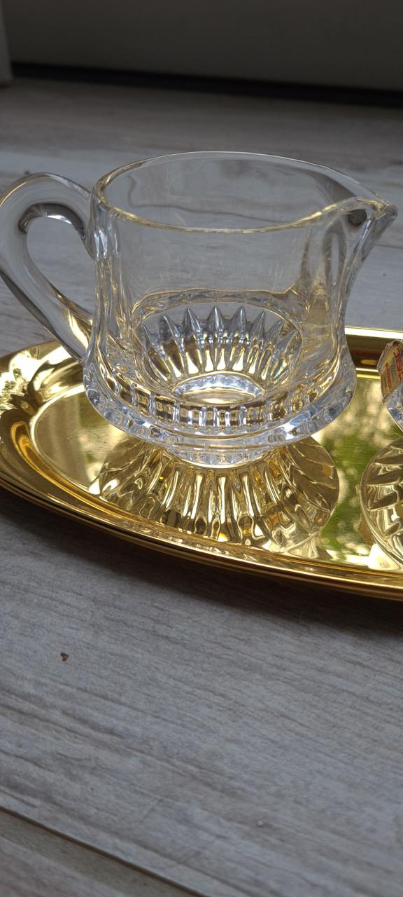 Kristallen melk en suikerset op goudschaal in oogverblindende staat