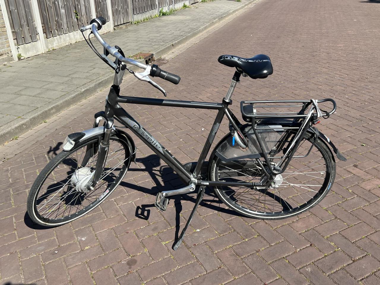 08 Zwart - grijskleurige herenfiets van het merk “ Gazelle ”.