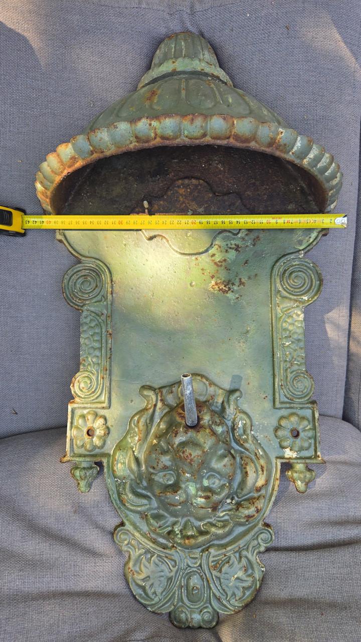 Antieke gietijzeren wandfontein met leeuwenkop