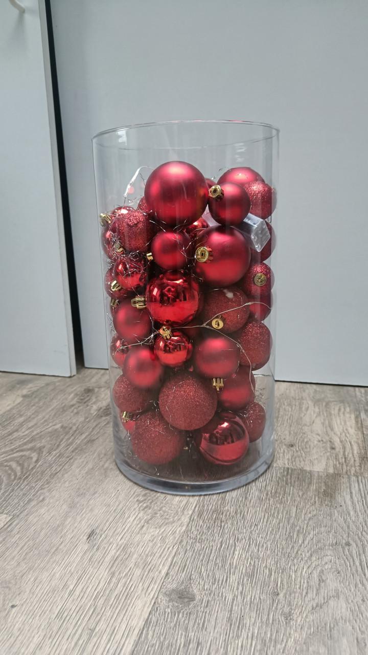 Glazen vaas met rode ballen en verlichting