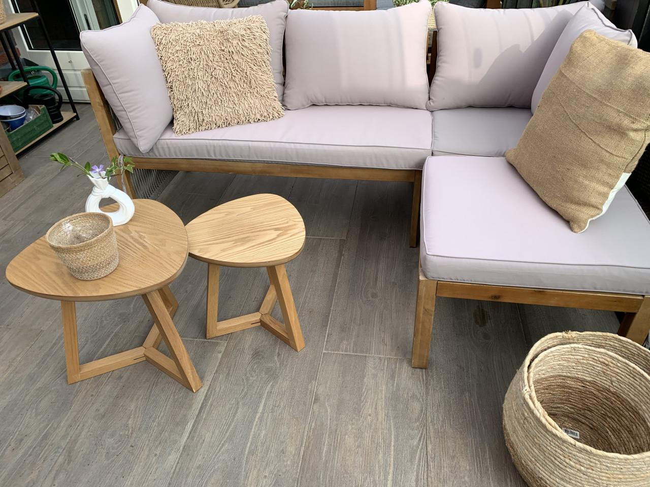 Houten loungeset met kussens en tafeltjes.