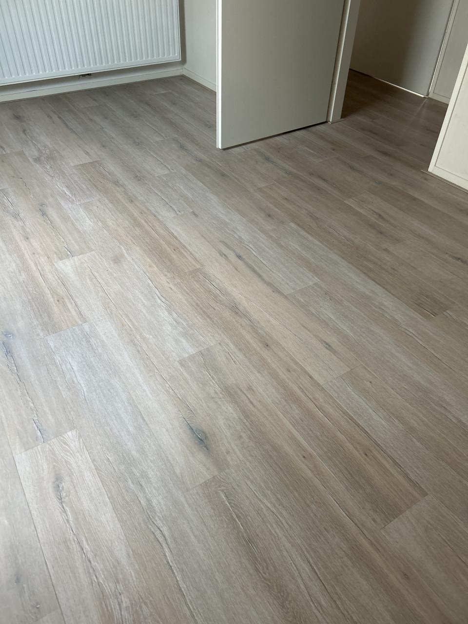 Laminaat licht met grijstinten v groef plinten en ondervloer