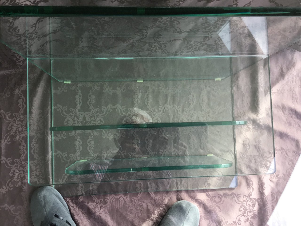 Twee glazen tafeltjes, waarvan één met lektuurbak
