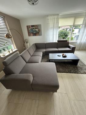 Mooie hoekbank met loungegedeelte en hoofdsteunen in Taupe kleur.