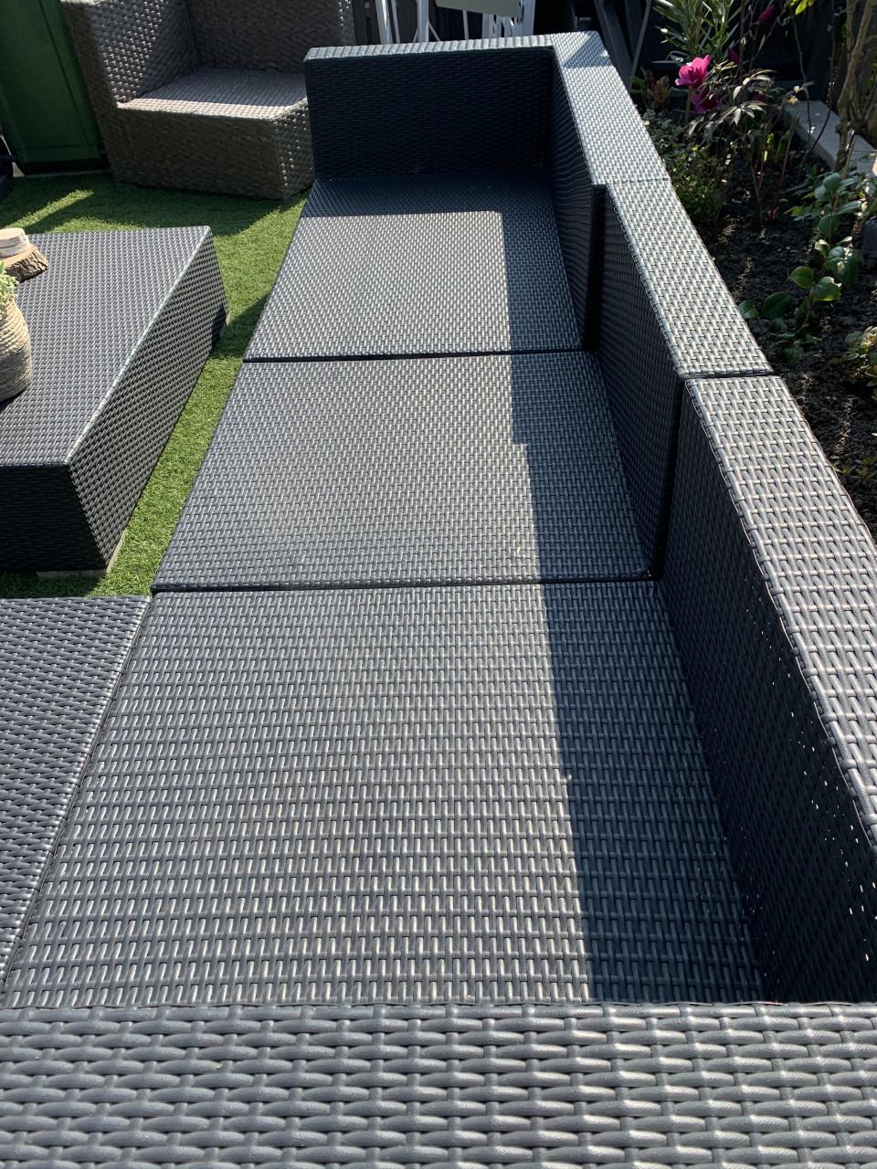 Wicker loungeset zwart met kussens en tafel.