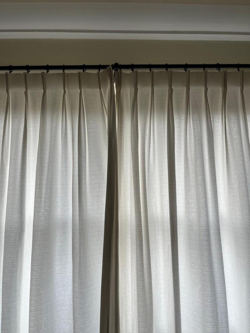 Mooie crèmekleurige gordijnen met zwarte roedes