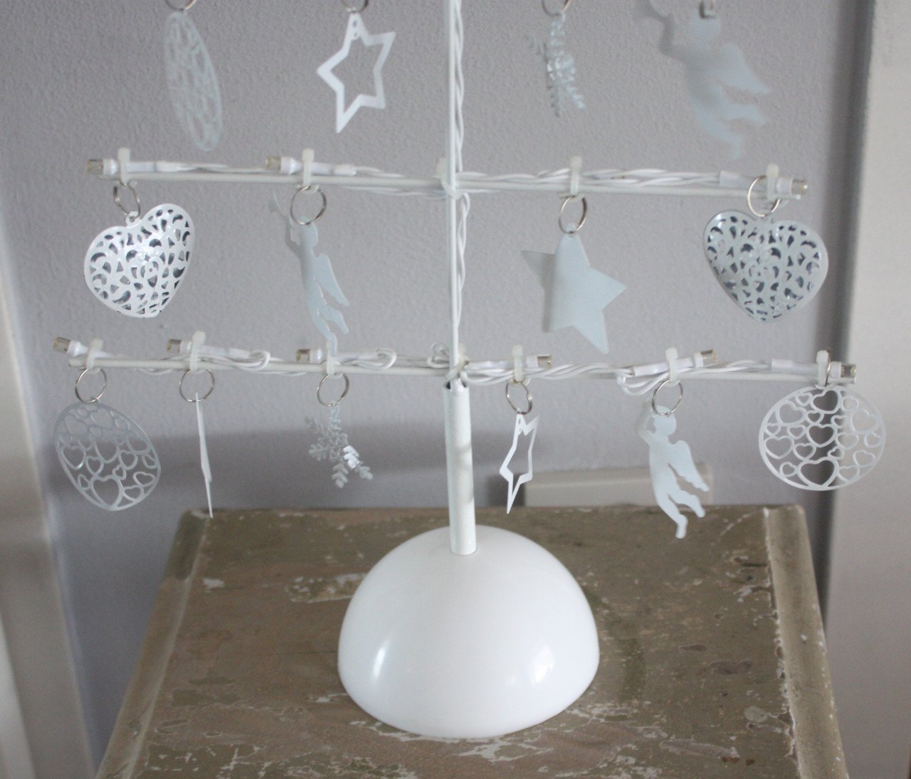 Metalen kerstboom met bedeltes en lichtjes