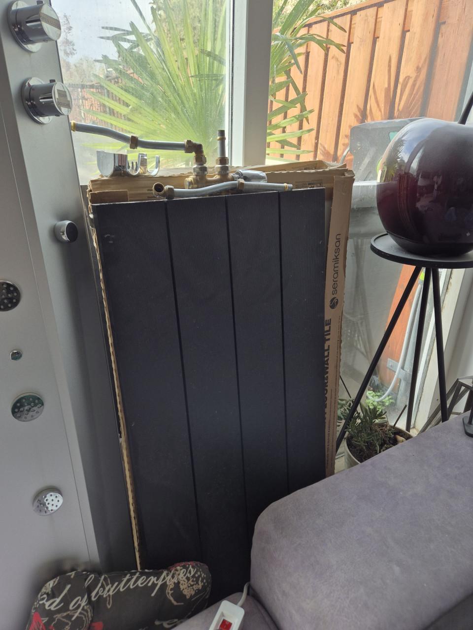 Design radiator zwart met toebehoren.