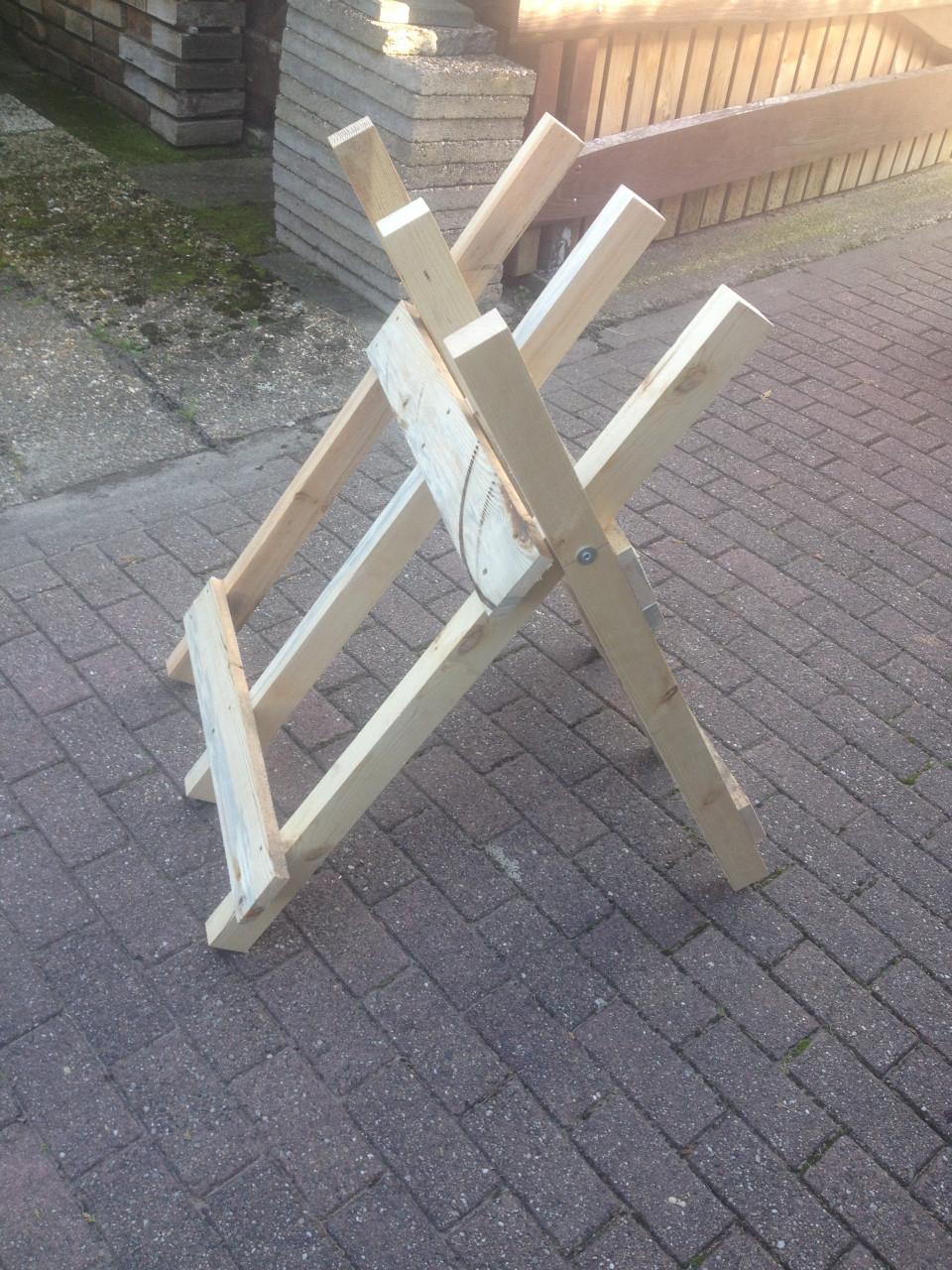 Rechtop hout doorzagen met kettingzaag en compacte zaagbok als werkbank