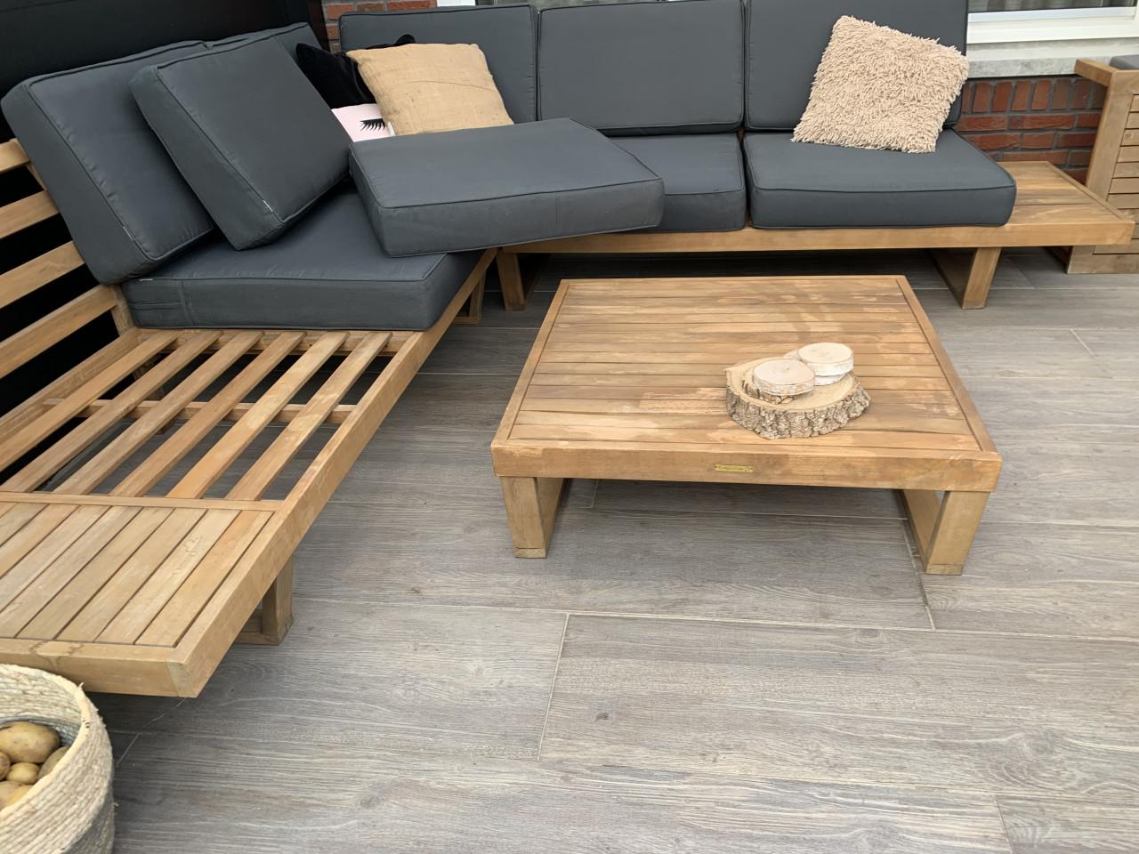 Hardhouten loungeset met kussens en tafel.