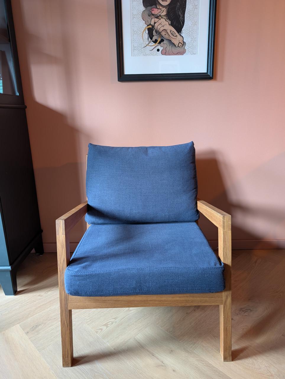 Moderne design fauteuil van massief hout met donkerblauwe kussens