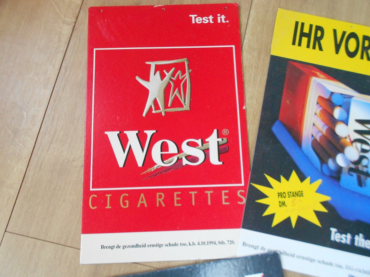 Vijf  reclameborden west cigarettes op geperst papier
