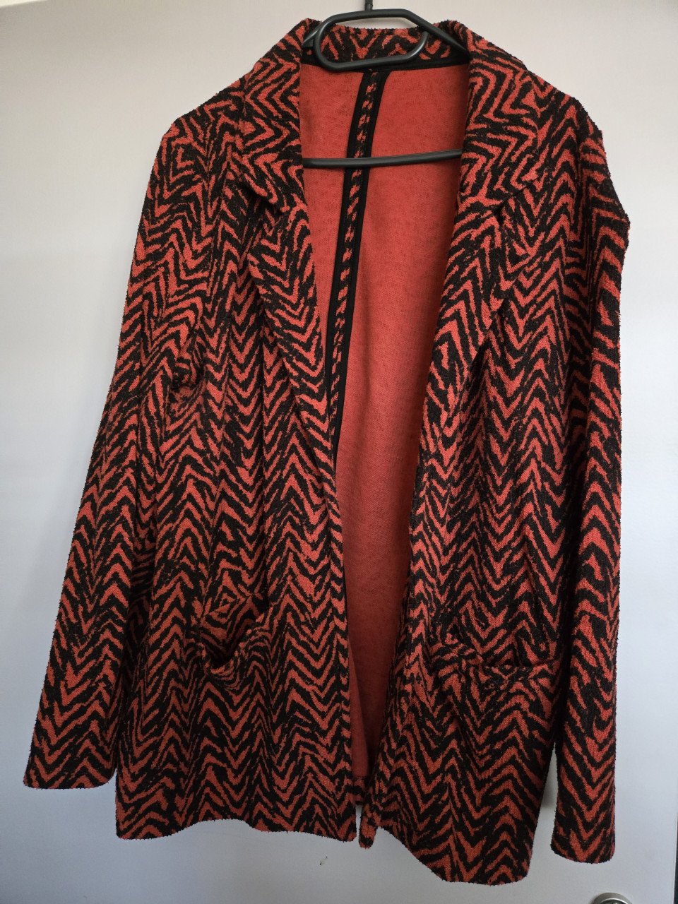 Vest rood/zwart met lange mouwen. 2 zakken, dikke, zware stof