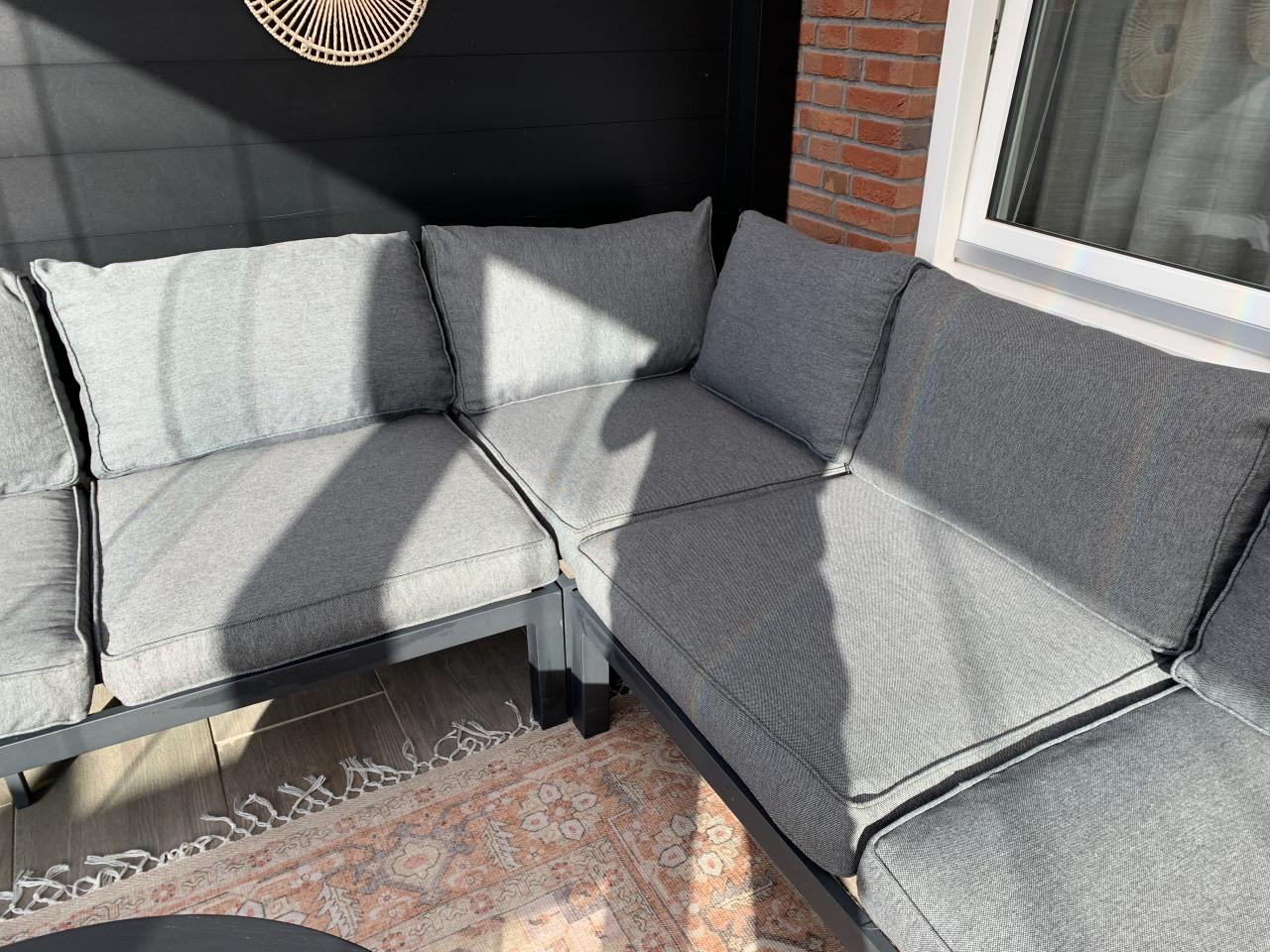 Zwarte loungset met houten plataus, kussens en tafel