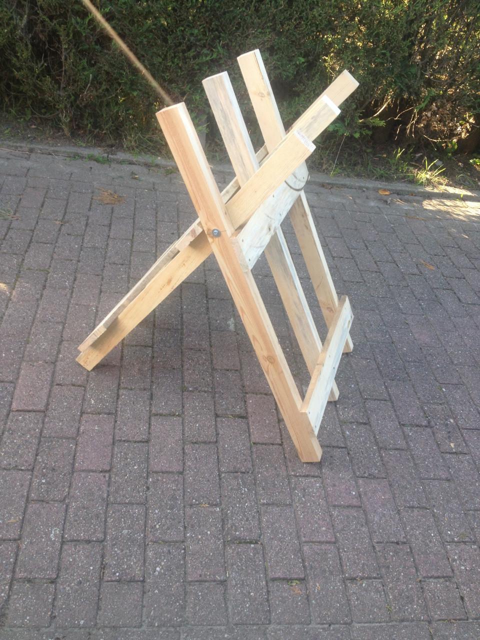 Veel haardhout door zagen met kettingzaag en compacte robuste zaagbok