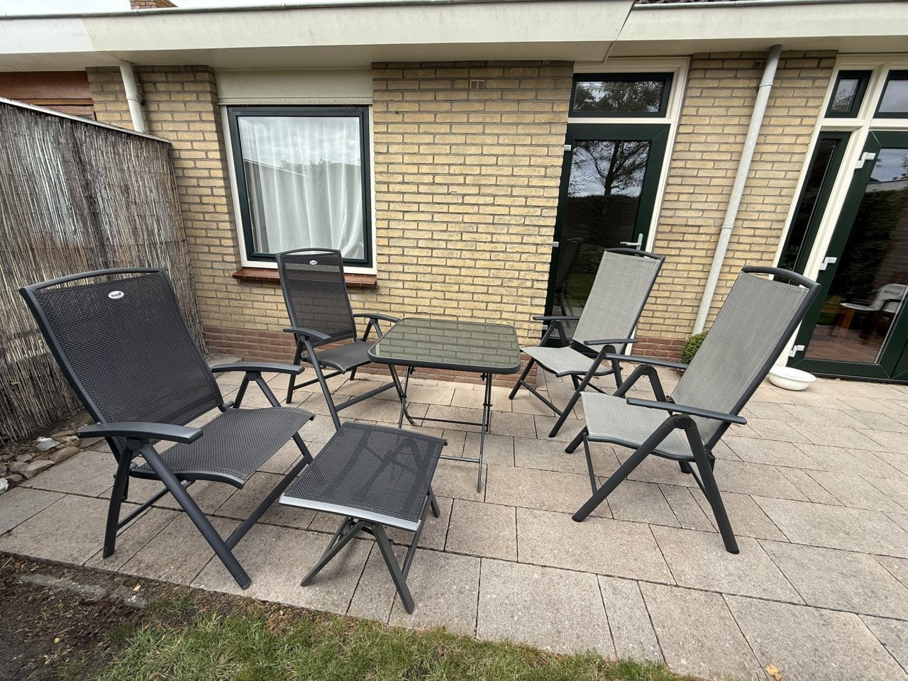 Te koop aangeboden: tuinset bestaande uit 4 stoelen, voetenbankje en tafel
