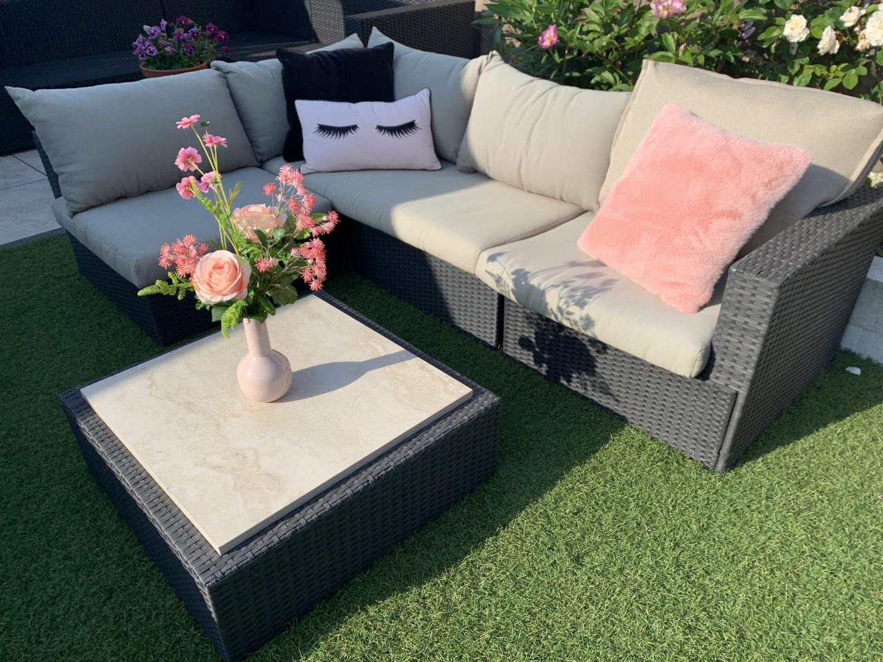 Wicker loungeset met kussens en tafel.