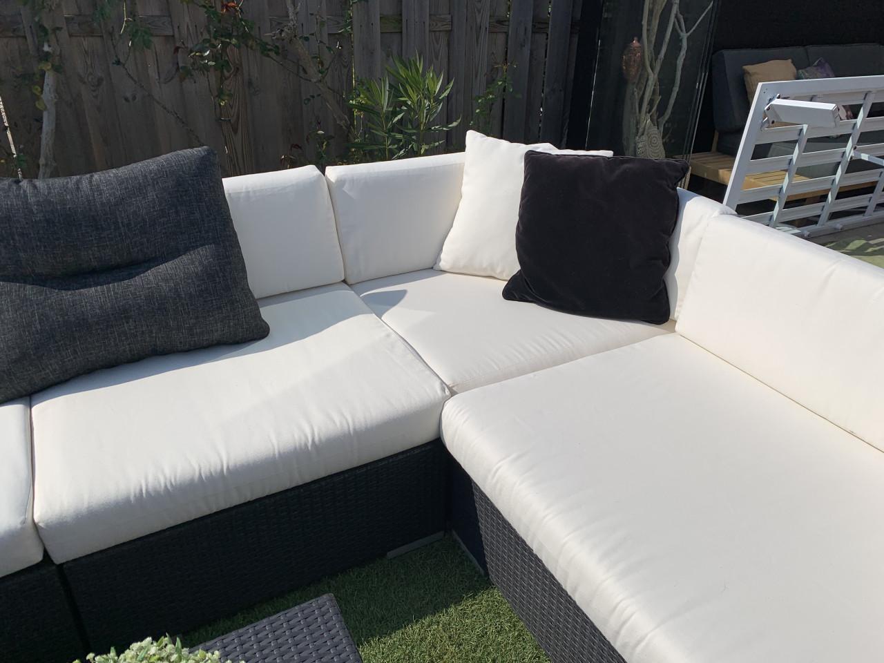 Wicker loungeset zwart met kussens en tafel.