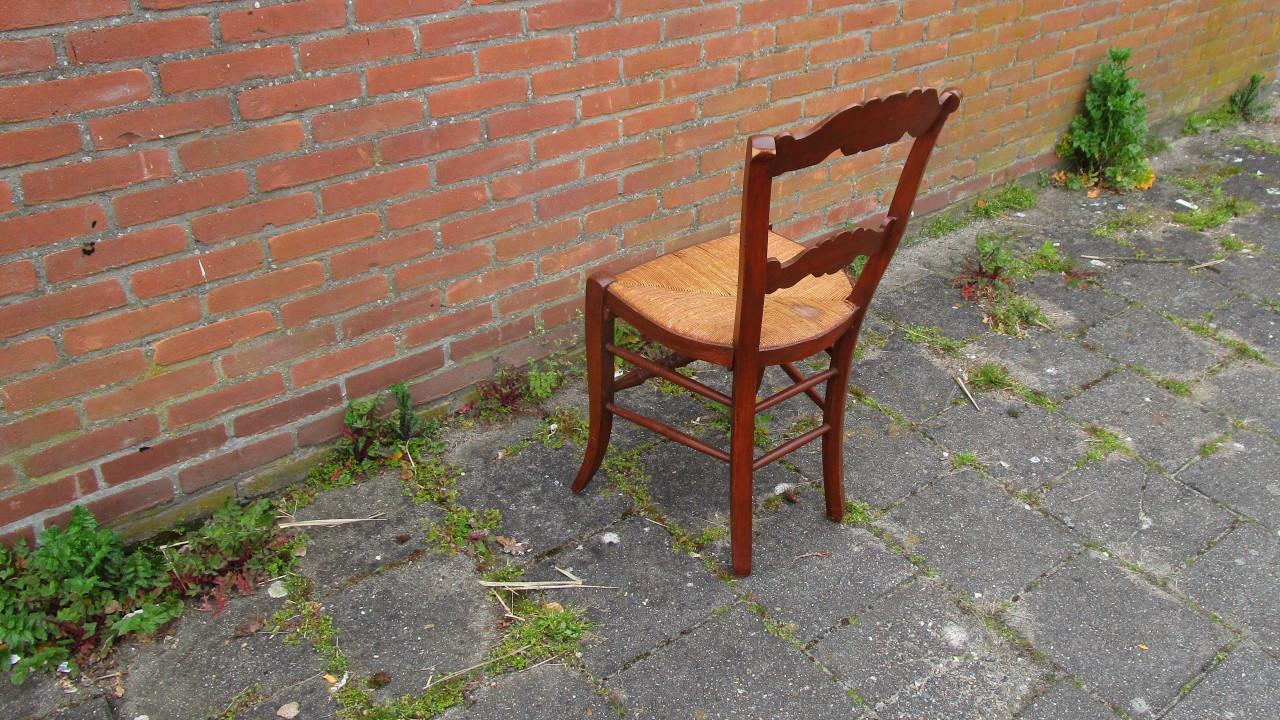 Antieke houten stoel met rieten zitting
