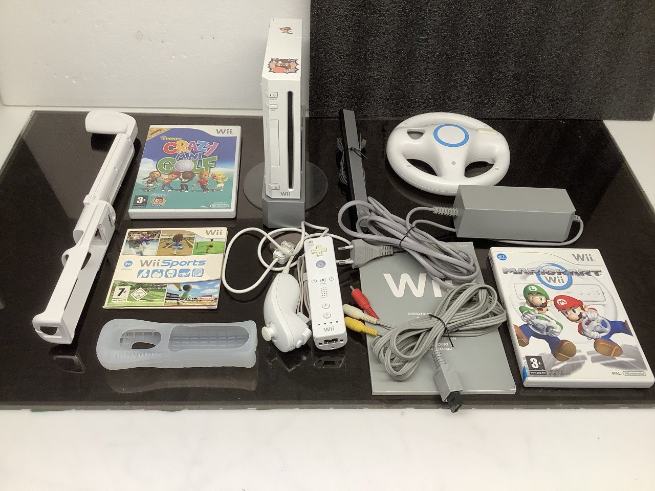 Nintendo Wii met controller en spellen, o.a. Mario Kart met stuur.