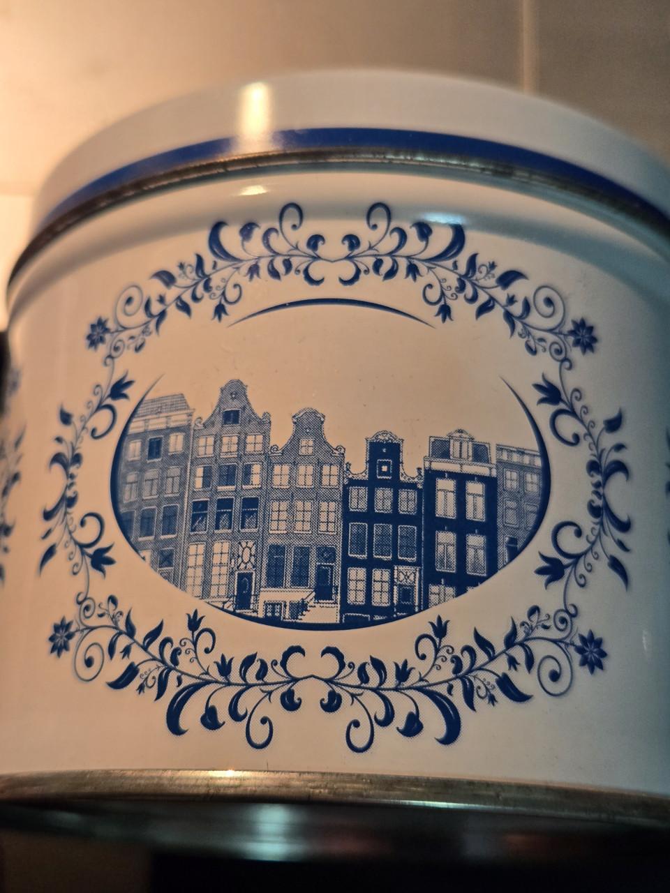 Delfts blauw stroopwafelblik met Amsterdamse grachtenpandjes.