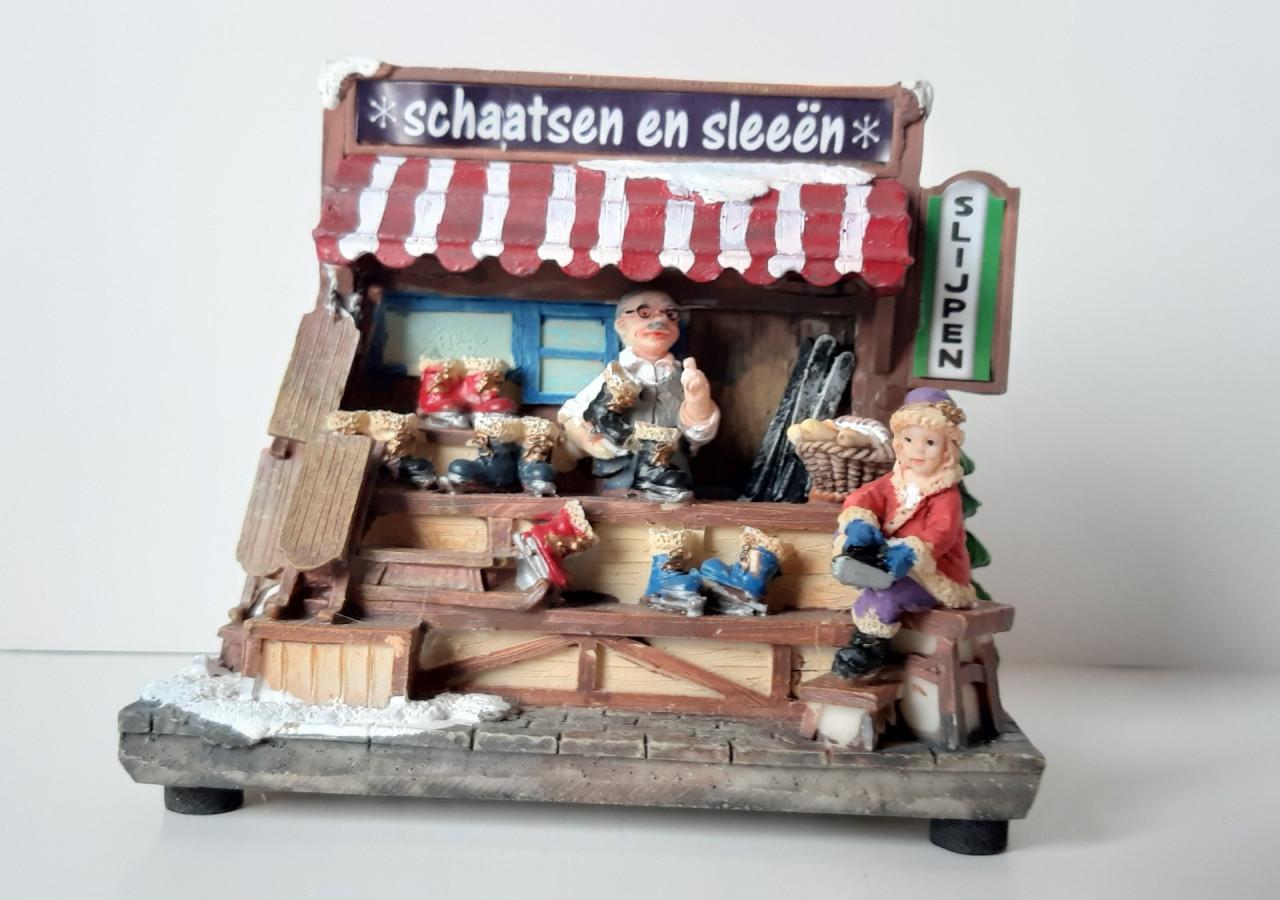 Kersthuisje, kersdecoratie met verlichting, schaatsen en sleeën