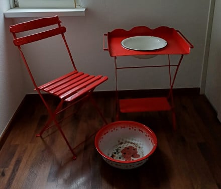Brocante rood bistrostoeltje met wastafelmeubeltje met kom en los teiltje