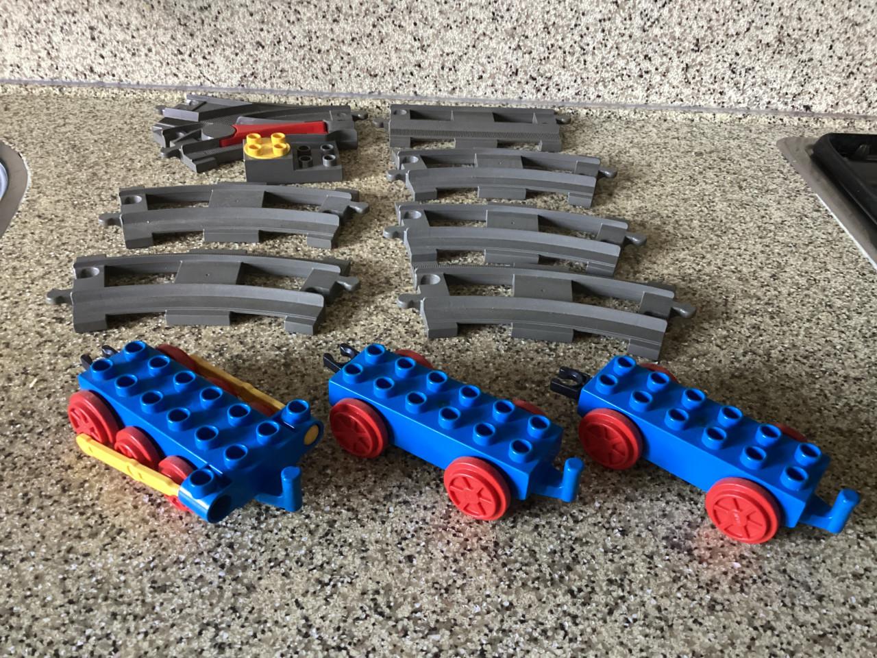 Lego. Duplo. 5 gebogen rails, 1 rechte en 1 wissel en 3 wagonnetjes.