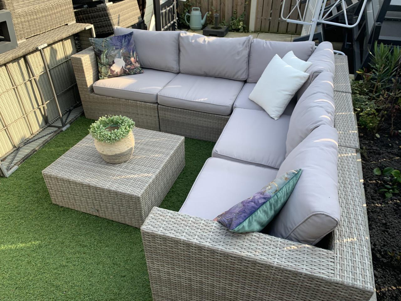 Loungset van pvc riet, met kussens en tafel.